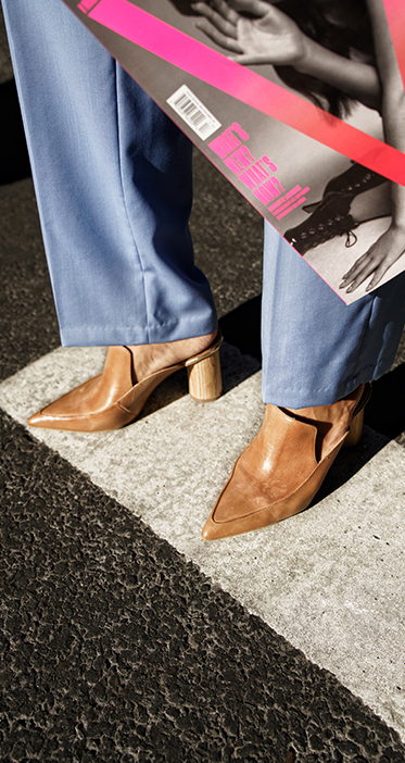 Helen Chik in brown camel shoes and blue trousers NYC crosswalk