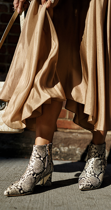 Helen Chik in snakeskin boots and snakeskin bucket bag with brown shiny dress